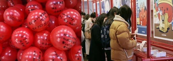 (좌측 : 외국인 방문객들이 적은 tvN 응원 메시지 볼  / 우측 : 티비엔프렌즈 굿즈(엽서,스티커 등)를 고르고 있는 방문객 모습)